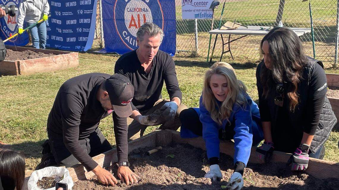 California Governor Gavin Newsom (center) planted seedlings in garden beds at Mary Ella Brown Community Center in southwest Fresno along with First Partner Jennifer Siebel Newsom (right, blue coat) and community members on Thursday, Nov. 10, 2022.