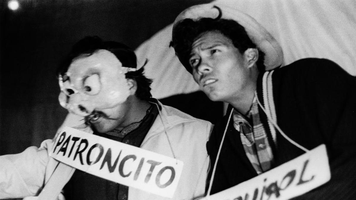 
Luis Valdez, left, in the mask, and Agustin Lira, right, portray scab workers while performing “Two Faces of the Boss” on top of a truck along Highway 99 in 1966.
