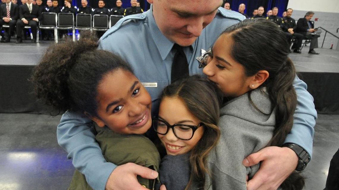 Jacob Fleischmann is surrounded by love from his sisters, from left, Charlee, 10, Maggie, 11, and Rhiannon, 14, after his pinning ceremony for being promoted to Fresno Police Cadet 1.