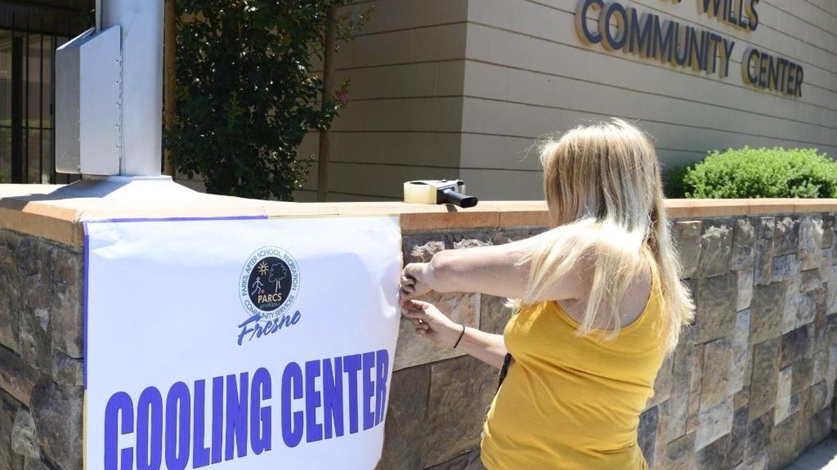 
Wendi Danyluk of the City of Fresno recreation department puts up a cooling center sign on the in front of the Ted C. Wills Center in Fresno Monday, June 8, 2015.
