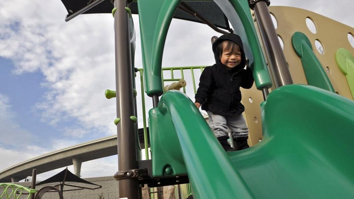 Savannah Cervantes, 1, plays with her mother Maribel Lopez at Romain Park’s new children’s playground Friday afternoon, Jan. 29, 2016 in Fresno, Calif. The playground was announced open Friday morning after the previous playground equipment burned in September 2015.