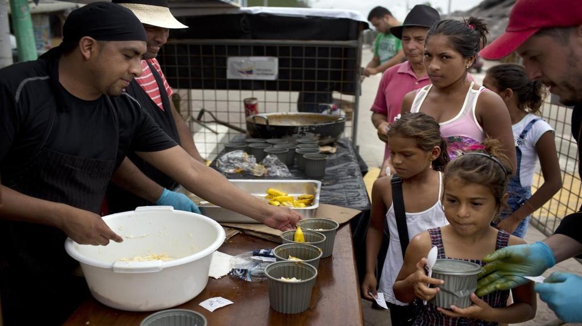 Volunteers serves food to children affected by the earthquake in Pedernales, Ecuador, Sunday, April 24, 2016. Ecuador’s government says the death toll from the 7.8-magnitude April 16 quake that flattened towns along the country’s coast has risen to 655 with another 48 people missing.