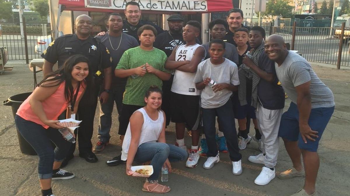 Fresno police officers, youth from the West Fresno Boys & Girls Club, chaperone Tommy Lowe (with hat) and local businessman Terrance Frazier at Thursday’s Taco Truck Throwdown at Chukchansi Park.