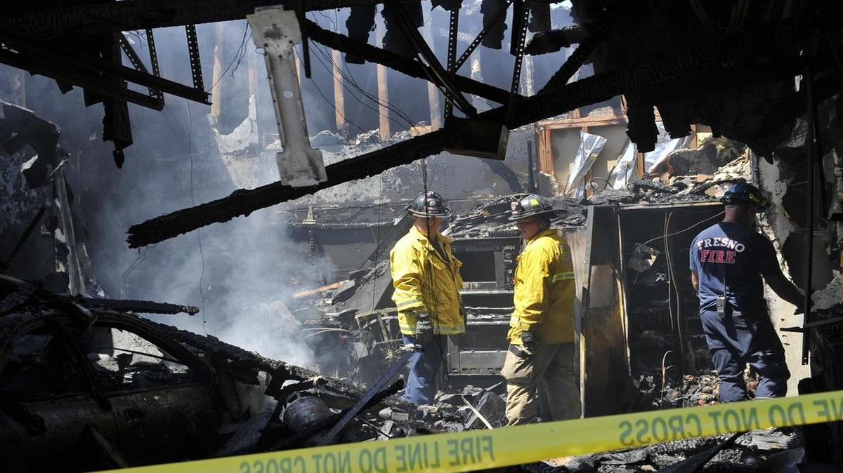 
Fire investigators search through a garage after a fire was reported and contained at 1334 W. Millbrae Avenue Friday afternoon, July 24, 2015 in Fresno, Calif. 
