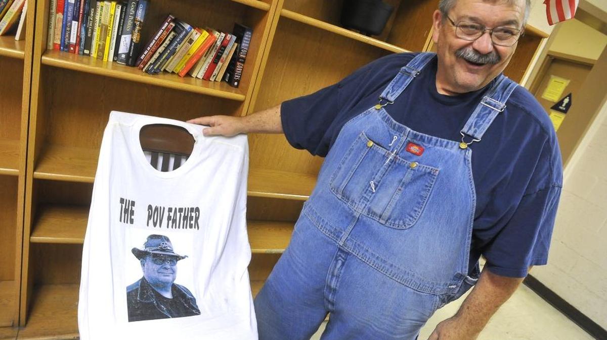 Poverello House founder Mike McGarvin holds a T-shirt displaying the words “The Pov Father” in this 2013 photo.
