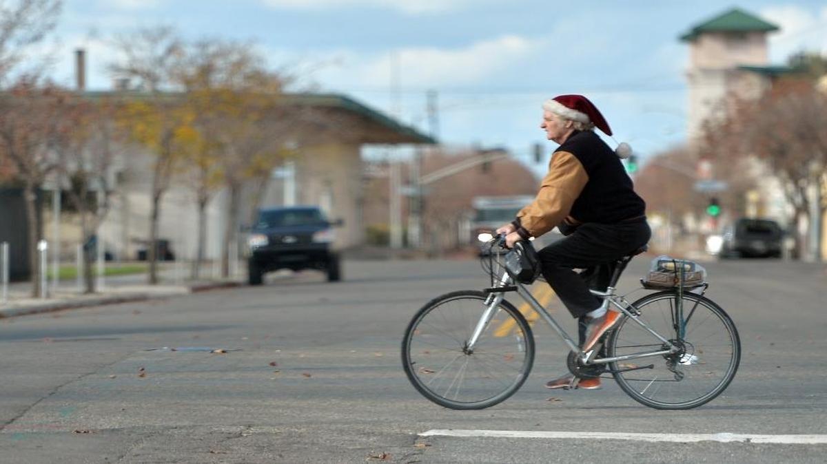 A bicyclist keeps his head warm with a Santa hat as he rides his bike on Ventura Street in downtown Fresno on Friday afternoon, Dec. 16, 2016.