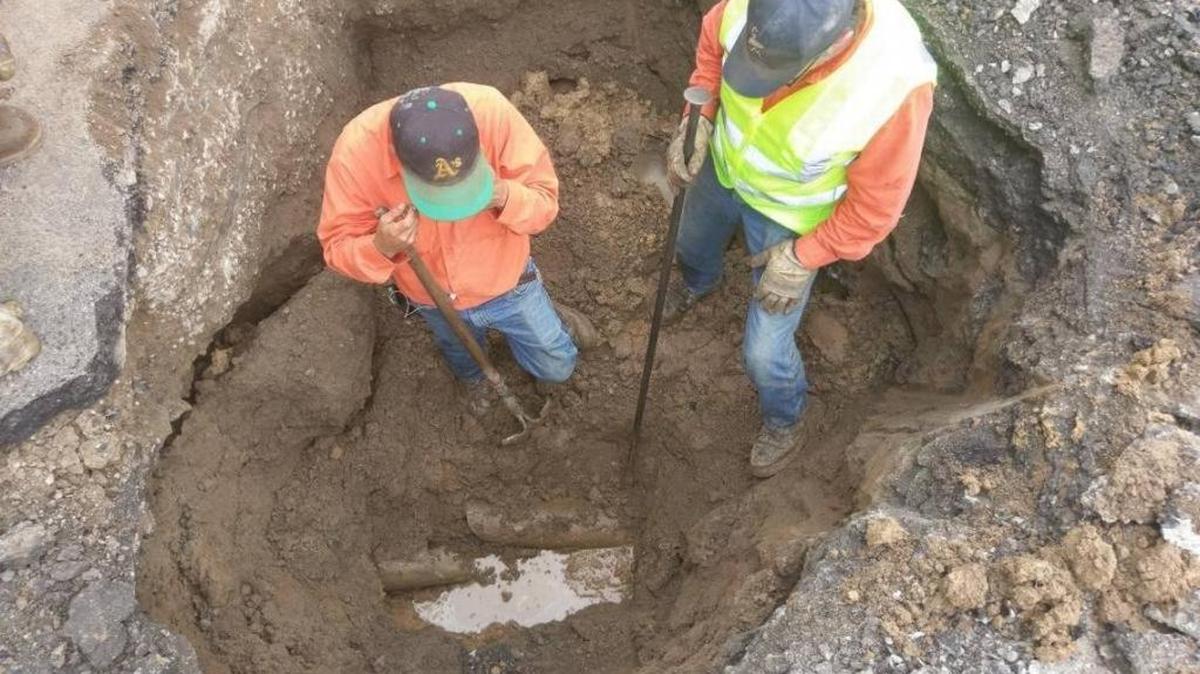 Madera County Road Department workers look at a pipe connected to the culvert that rotted out and broke open, causing the hole to rupture on Road 427. The hole was expected to be repaired, and the road reopened by 5 p.m. Thursday.