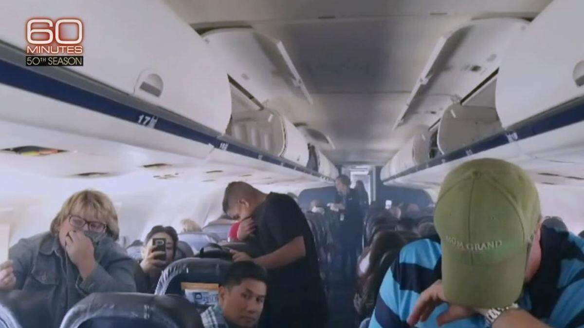 A still photo from video aboard a September 2017 Allegiant Air flight from Las Vegas to Fresno shows people breathing through their clothing to avoid inhaling fumes that filled the cabin after the airplane landed at Fresno Yosemite International Airport. A flight attendant can be seen handing out dampened napkins to passengers.