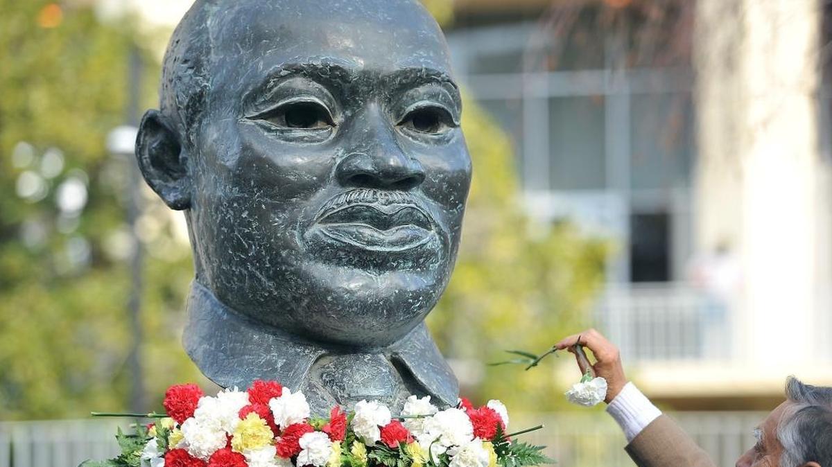 Dr. Sudarshan Kapoor places carnations on the MLK statue during the Garlanding and Flower Ceremony for Rev. Dr. Martin Luther King, Jr. on Friday, Jan. 15, 2016 at Courthouse Park in downtown Fresno.