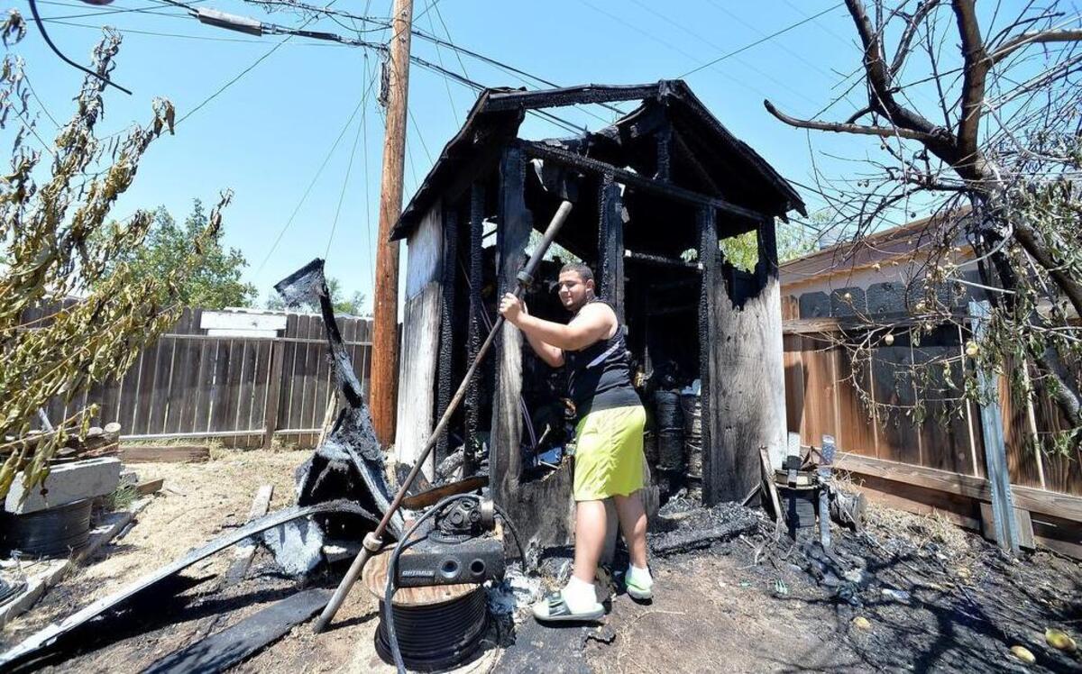 
Ritcharde Cisneros, 17, goes through the burned remains of his family’s storage shed that caught fire Sunday morning on San Pablo Avenue in central Fresno.
