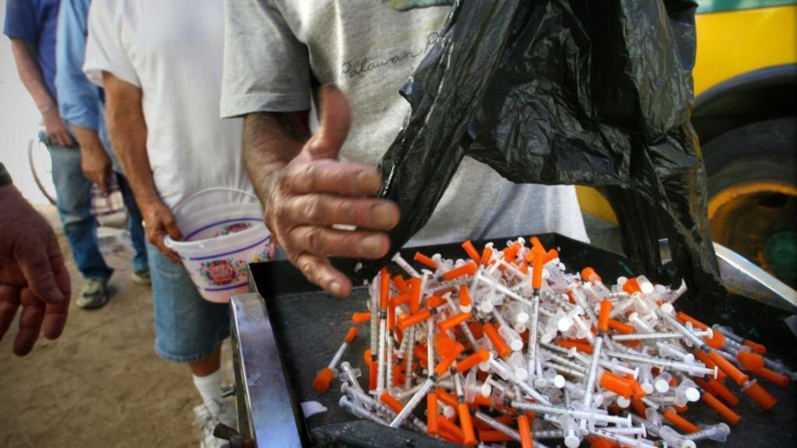 Clients of the Fresno Needle Exchange turns in hundreds of used hypodermic needles for disposal in September 2011 at the mobile needle exchange and mobile medical clinic set up near Roeding Park, for an hour.
