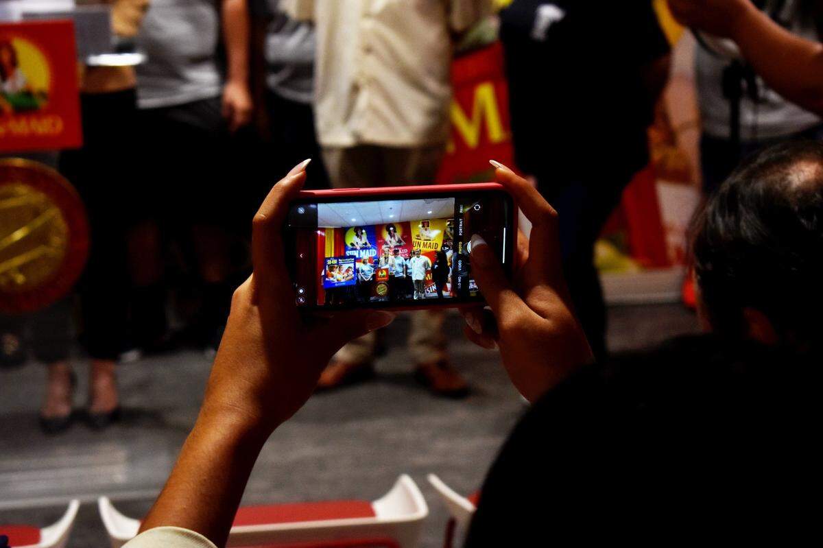 A press conference attendee snaps a photo of the Teamsters 431 union members standing beside Ashley Alvarado, president of Teamsters Local 856 union, in support of the Buy American Food Act on Sept. 14, 2022 at Sun-Maid Growers of California headquarters in Fresno.