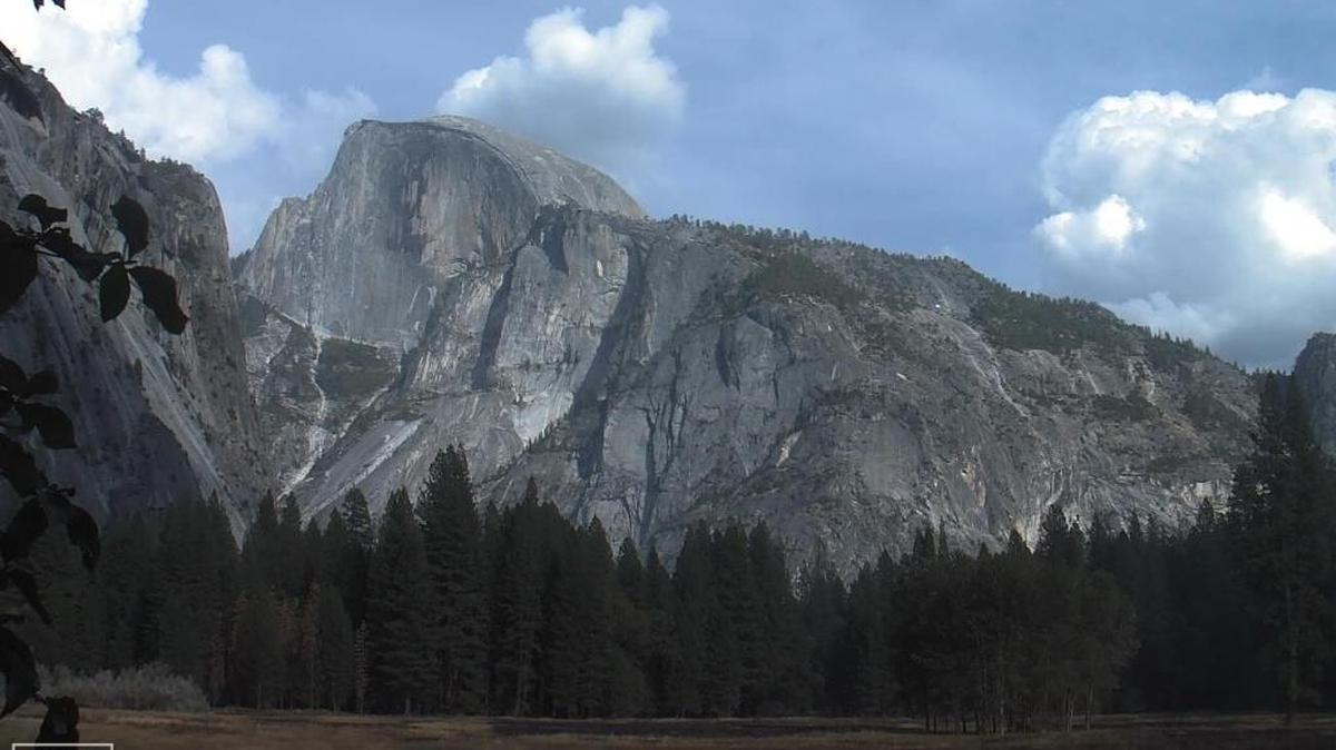 A view of Half Dome in Yosemite Valley from a webcam in the Ahwahnee Meadow. Clouds from the storm system fill the sky behind the granite monolith.