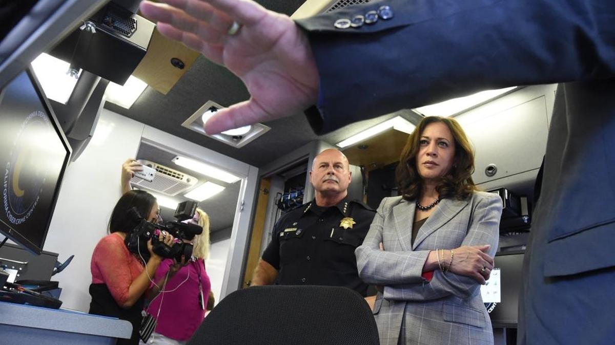 State Attorney General Kamala Harris and Fresno Police Chief Jerry Dyer listen to Department of Justice software specialist Tim Whitfield, right, talk about the new cyber response vehicle on Monday, Oct. 10, 2016, at Fresno State.