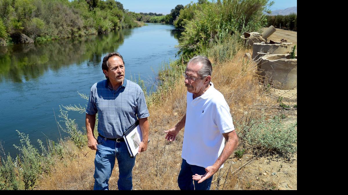 
Resource management mitigator John Buada, left, and Herb Lang of the Running Luck Ranch near Sanger stand on the bank of the Kings River on the ranch property one day last July. Lang is working to get through the environmental review in hopes of building a gravel mine plant on the property.
