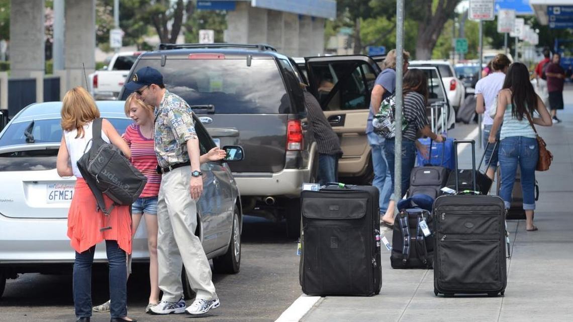 Passengers get dropped off by families and friends in front of the terminal at Fresno Yosemite International Airport in this file photo. Rideshare companies Uber and Lyft are averaging about 3,700 rides a month to and from the airport.