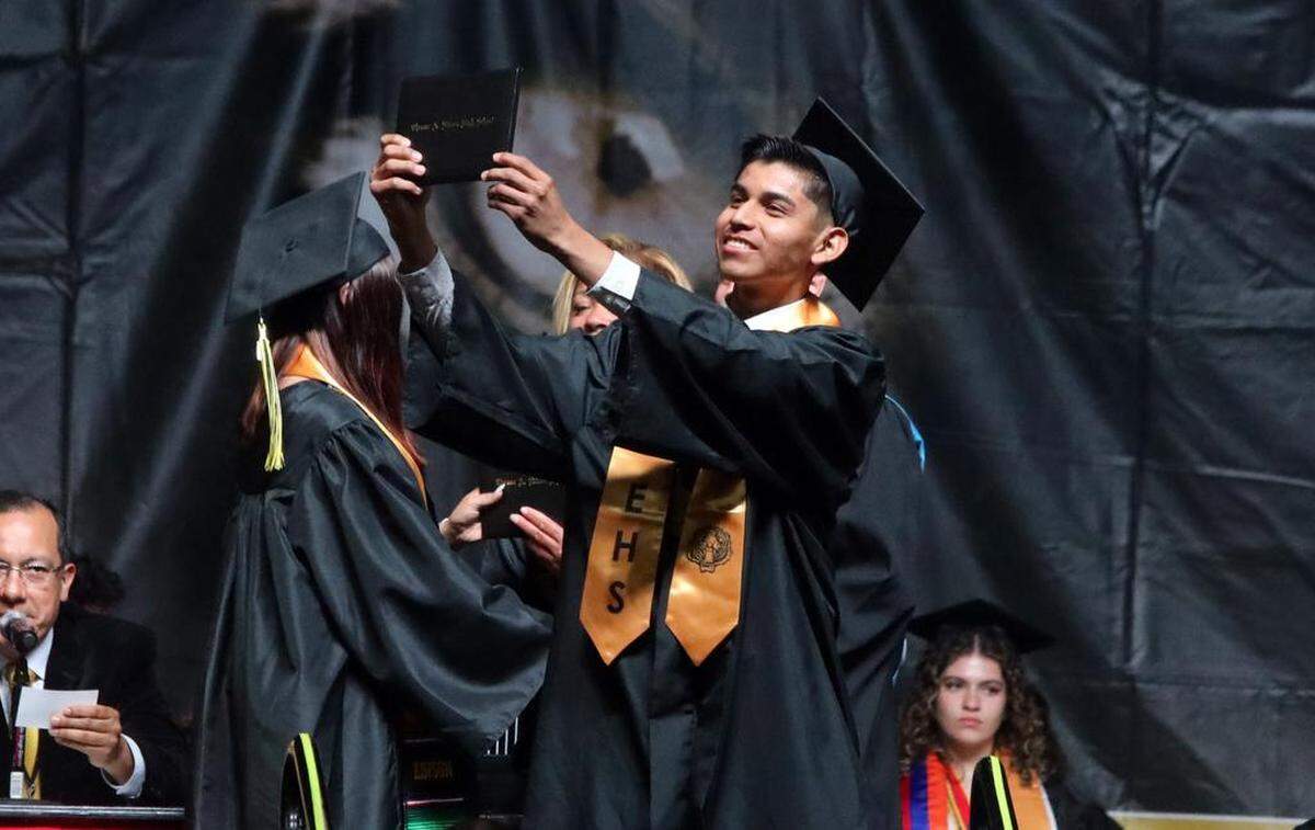A graduate holds up his diploma during the Edison High School graduation ceremony at the Save Mart Center on June 5, 2023.