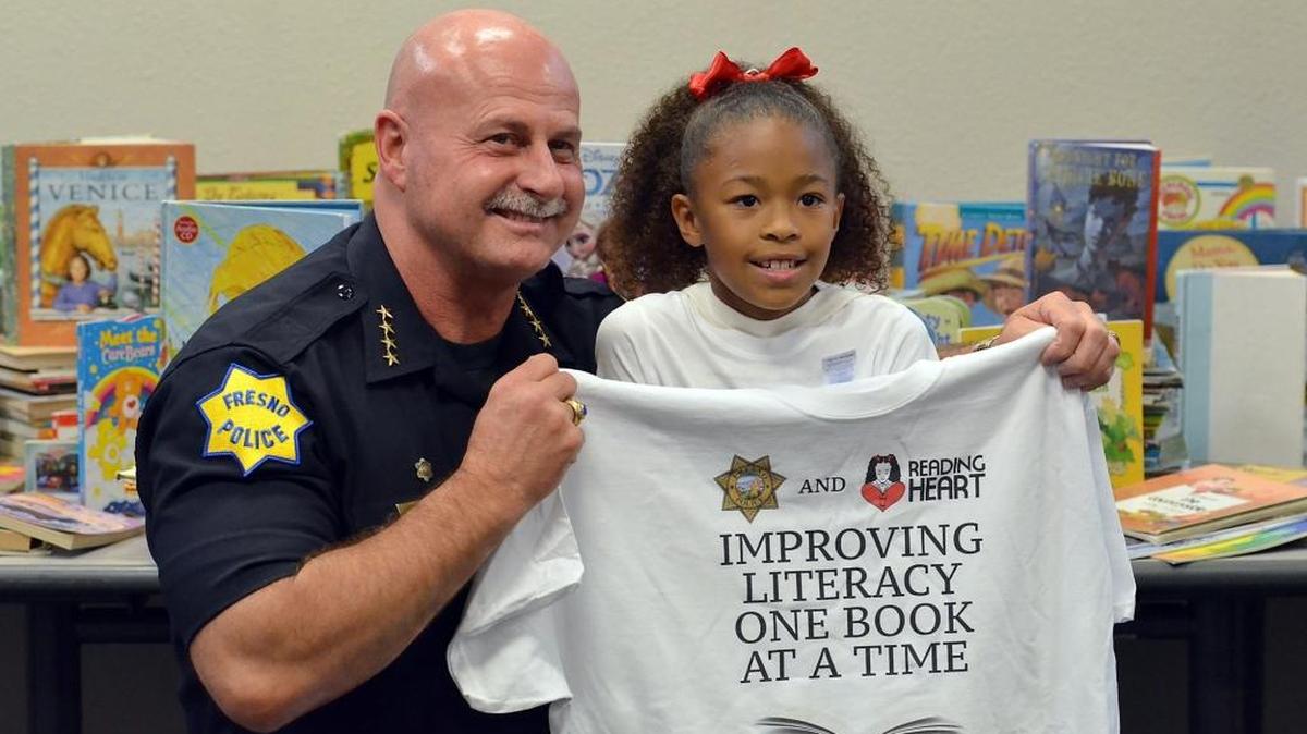 Fresno schoolgirl Danay Ferguson, 9, right, poses for a photo with Fresno Police Chief Jerry Dyer after announcing a partnership with the police department.