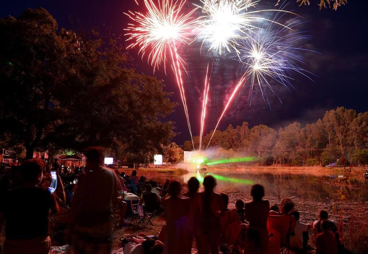 Revelers watch from the banks of a pond at Wild Water Adventure Park in Clovis as fireworks are shot off during the Star Spangled Revue show in 2017.