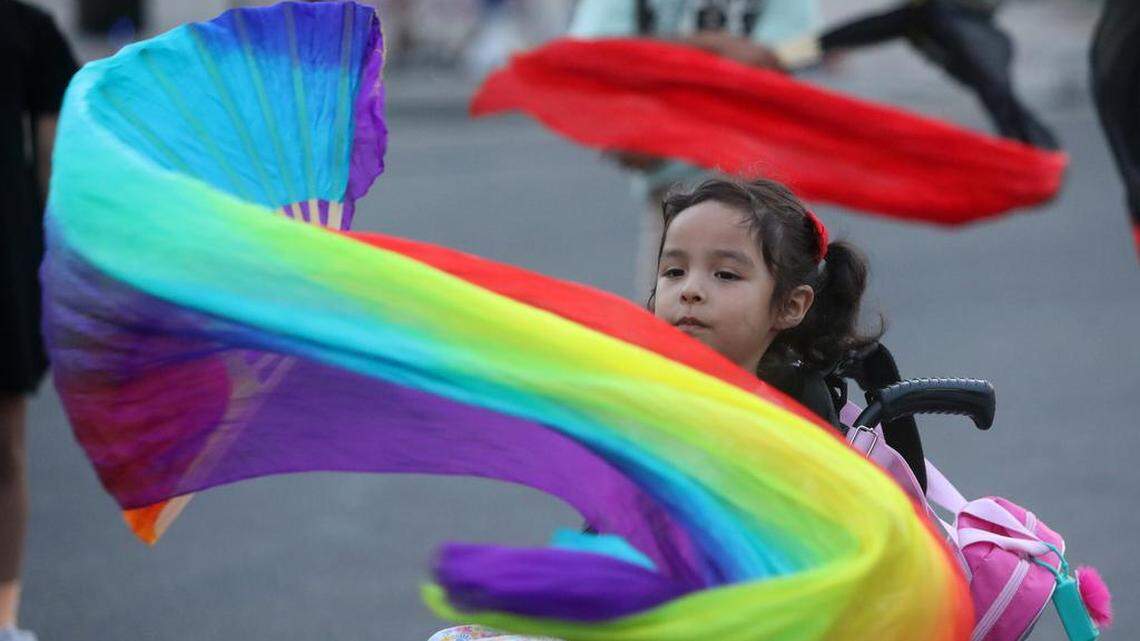 Una niña en silla de ruedas juega con una bandera del orgullo en el festival callejero de la Comisión de Oportunidades Económicas de Fresno "Iluminemos nuestro orgullo y nuestra salud mental" en Fulton Street, el 24 de junio de 2023. La celebración fue organizada por el Centro de Recursos EOC LGBTQ+.