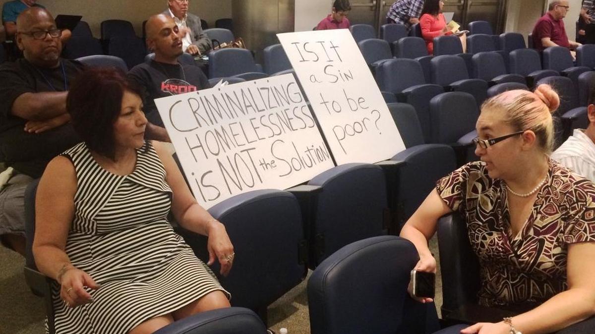 Alicia Ortega, left, of Clovis and Charlene Delgado of Fresno brought signs to Thursday's Fresno City Council to object to a proposed ban on homeless camping.