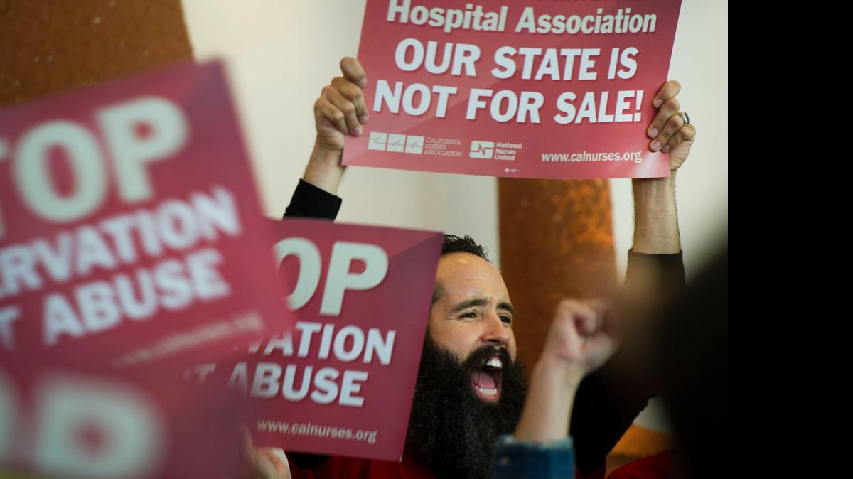 
Matt Elliott, a registered nurse in the ICU at Kaiser South Sacramento, rallies with hundreds of members of the California Nurses Association on Tuesday in the lobby of the California Hospital Association headquarters before marching on to the Capitol, in part to protest the recent demise of the latest bill requiring nonprofit hospitals to better account for the charity care they provide.
