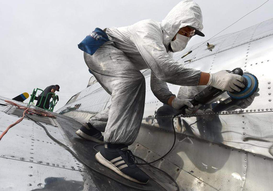 Perched on a massive wing, B-17 Archaeology volunteer Abraham Carranza brings back the gleam to aluminum panels-or skin- of "Preston's Pride," a B-17 bomber, a task done for the first time in at least 60 years, at Mefford Field outside of Tulare, Wednesday, April 18, 2018.