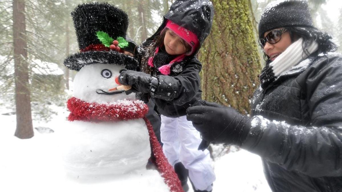 Samantha Duran, left, 6, of Sanger, builds a snowman with her aunt, Rolinda Hernandez, in the fresh snow at Grant Grove on Sunday in Kings Canyon National Park east of Sanger.