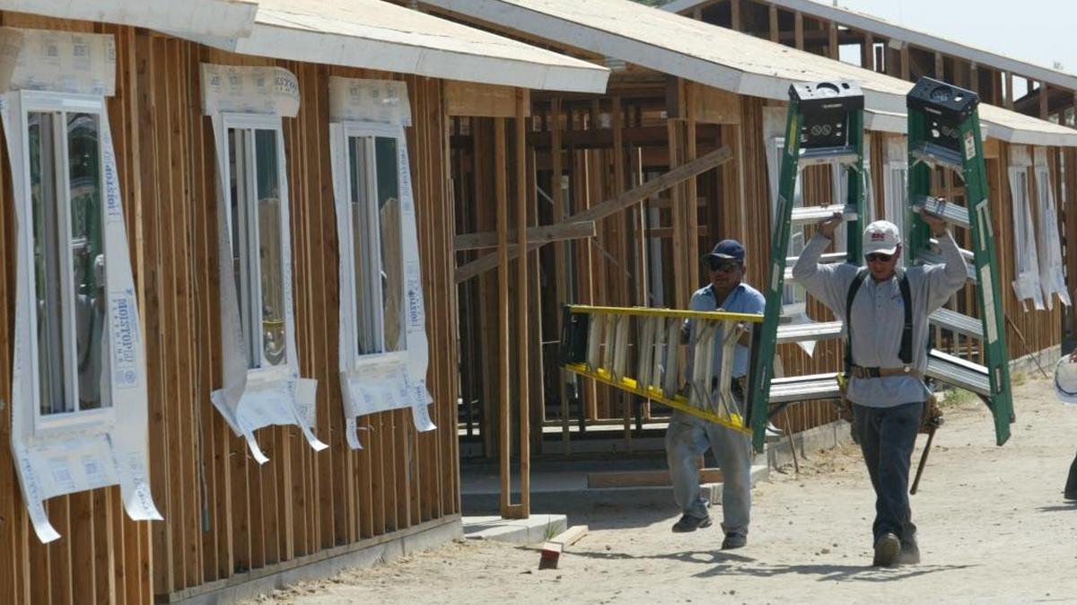 Two members of a Self-Help Enterprises project in Biola carry ladders as they help a neighbor build a house in this 2007 photo. Self-Help Enterprises plans to build a 40-unit apartment project for low-income seniors, as well as a “sweat equity” neighborhood of 26 single-family homes, in southwest Fresno.