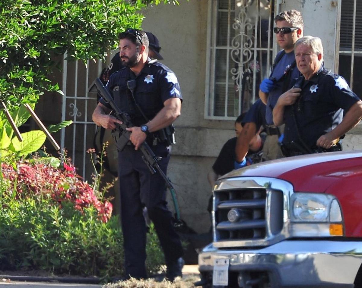 Fresno police officers stand by at the scene of the shooting at 5267 E. Hammond Ave. in east-central Fresno on Tuesday morning, June 6, 2017. Police said four people were shot; three are dead.