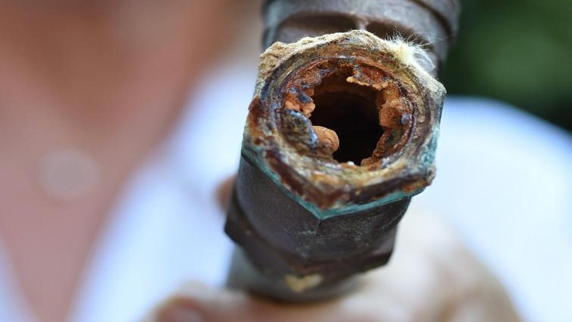 Karen Micheli shows an example of rusting from the inside piece of plumbing, the water main shut-off, that is being replaced along with all of the interior galvanized pipes in her north Fresno home.