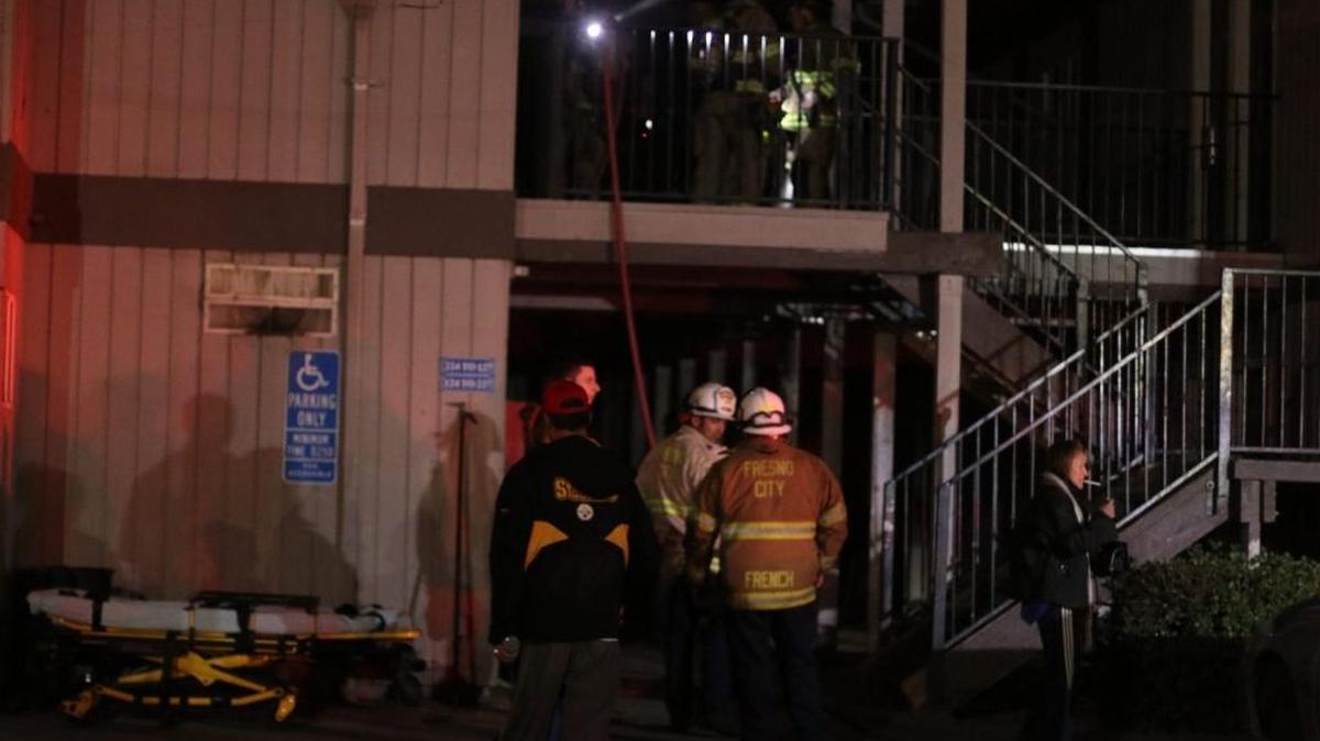 Firefighters assess the damage to a room at the Travel Inn & Suites on Parkway Drive in central Fresno on Sunday night, Nov. 19.
