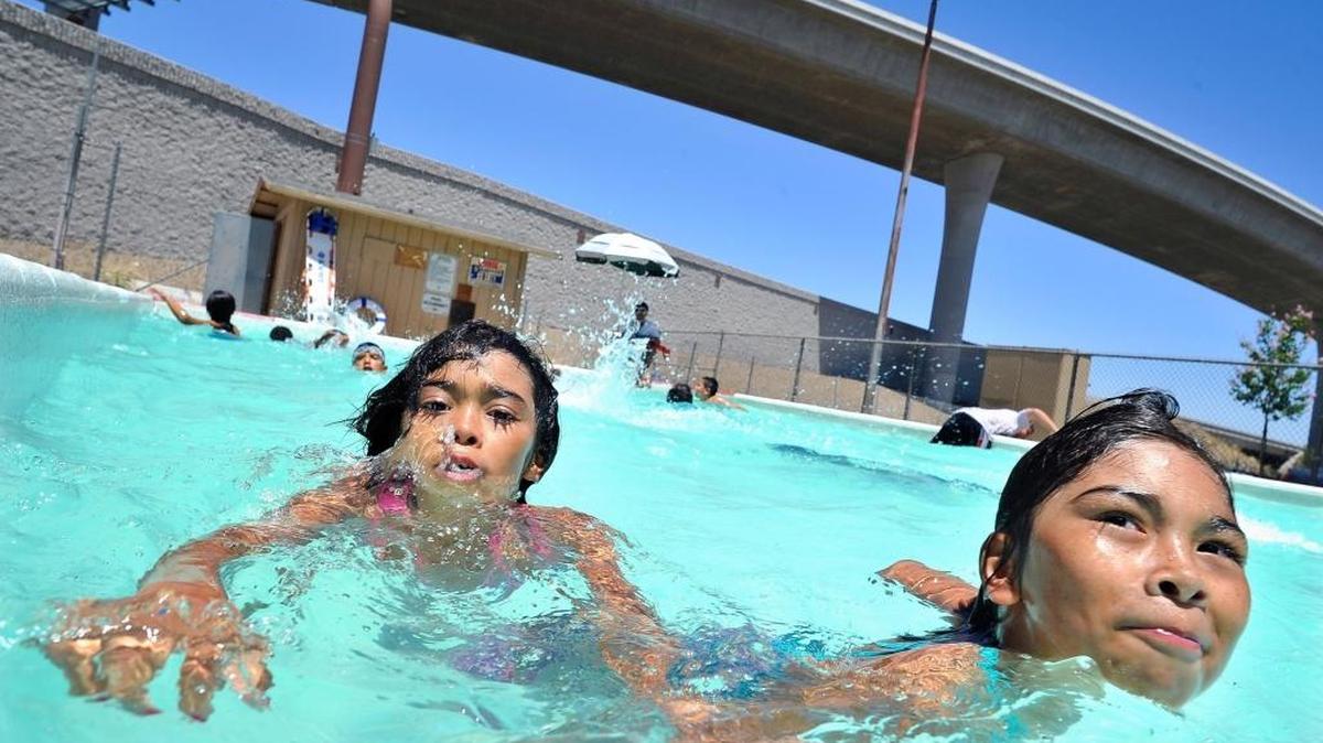 Sisters Diana, 7, left, and Linda Aguilar, 9, cool off in the Romain Playground learner pool in June 2015. The city of Fresno’s swimming pools and learner pools will reopen starting Monday.