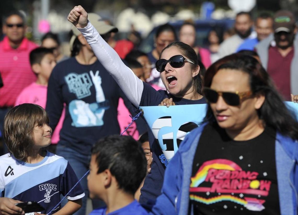 Karina Cisneros with the Ayers Polar Bears soccer club raises her fist as she marches with other soccer families calling attention for Fresno to retain ownership of a 49-acre parcel along South Peach Avenue. The marchers insisted the land should be used as a soccer field facility for youth soccer leagues.