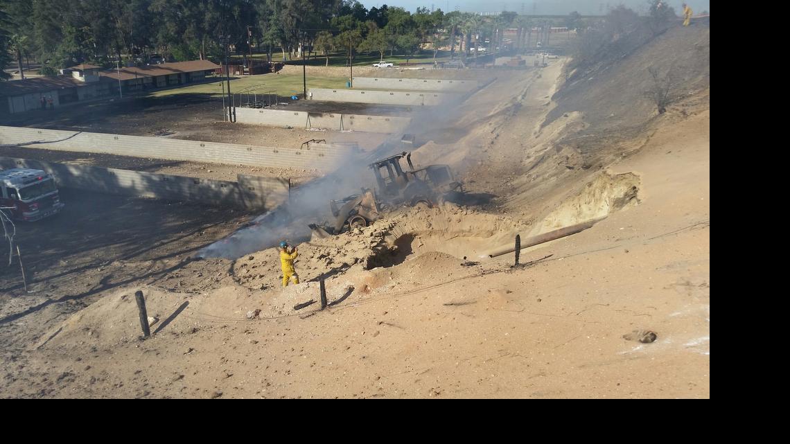 
An investigator combs the area where a Pacific Gas & Electric Co. pipeline ruptured April 17, 2015, at the Fresno Sheriff’s Foundation shooting range. The explosion left one man dead and 12 injured. A report for the California Public Utilities Commission released Monday, July 6, 2015, concludes that the front-end loader visible in the photo caused the rupture.
