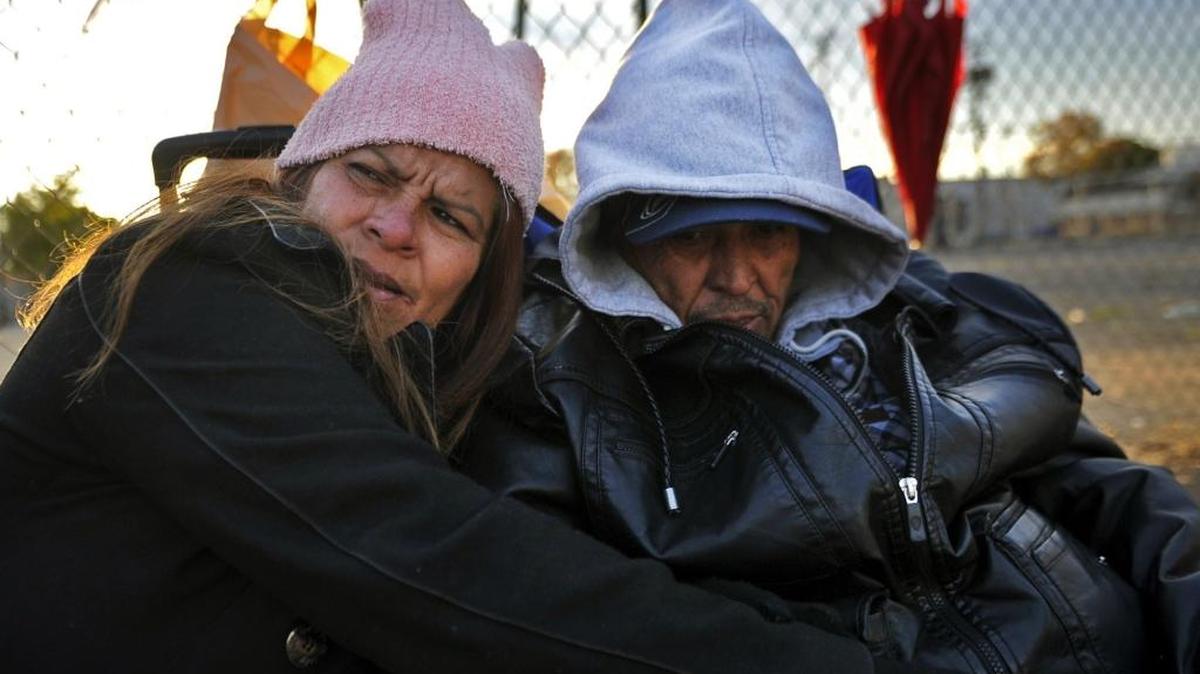 Julie, left, and Jesus Alvarez, right, sit on the sidewalk along G Street Friday evening, November 27, 2015 in downtown Fresno, Calif. Both said they’ve been living on the streets in the area for two years.