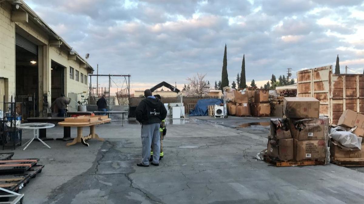 Salvation Army workers and Fresno firefighters survey the damage after a predawn fire Thursday, Feb. 22 at a warehouse.
