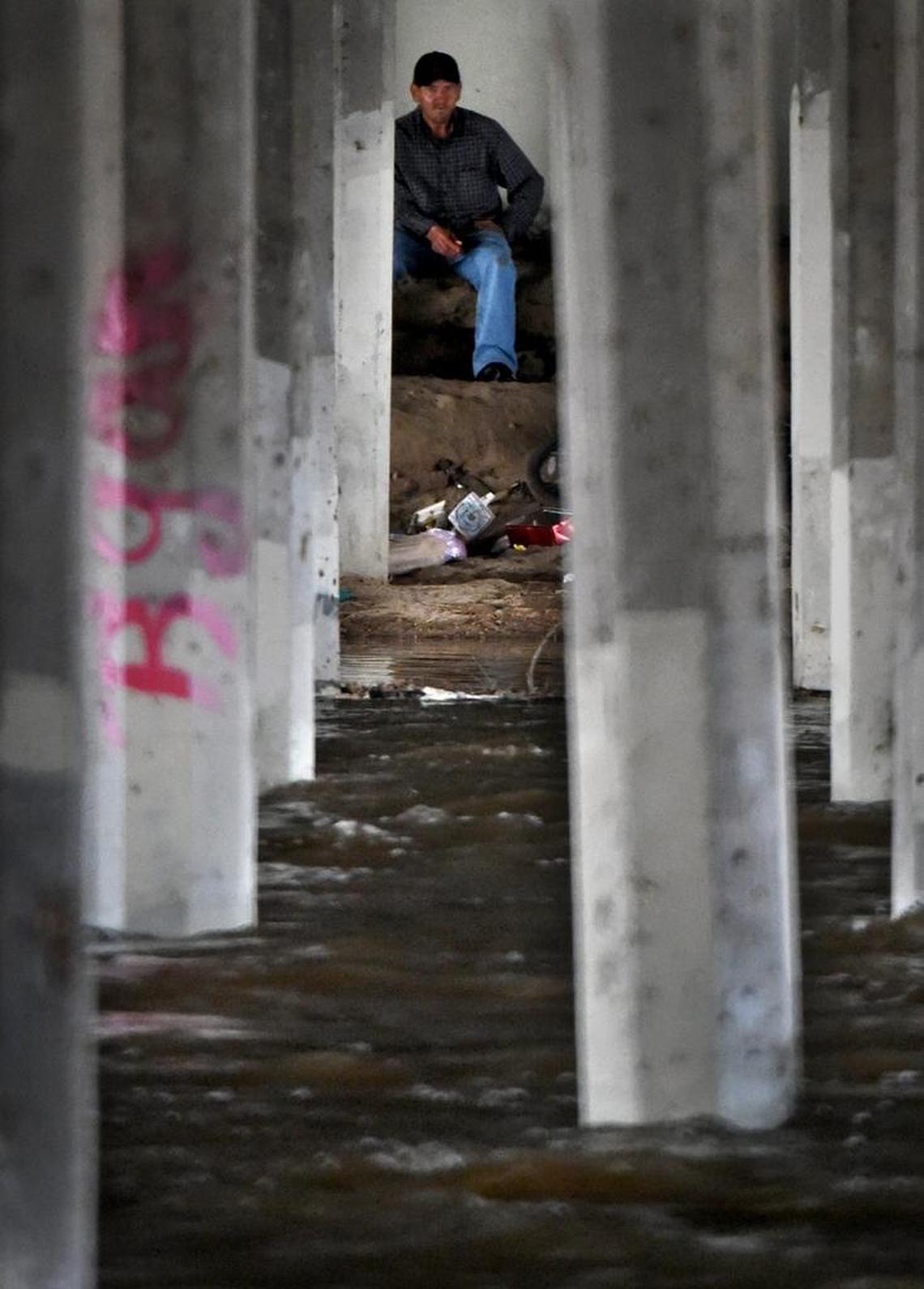 The muddy waters of the fast-flowing Fresno River rises on a homeless encampment under the Schnoor Street bridge as it makes its way through Madera Wednesday afternoon.