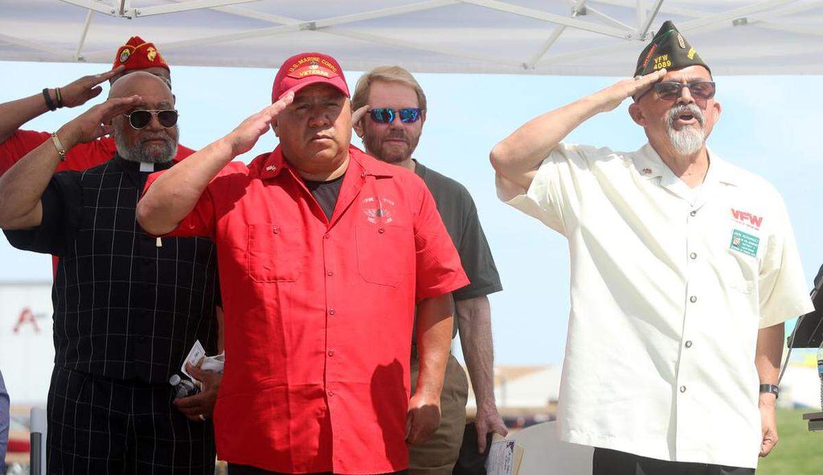 Kings County Supervisor Richard Valle (in red) salutes next to VFW District 3 Vice Commander John Hernández during the unveiling of The Five Pillars of Freedom veterans memorial at Gateway Park in Corcoran on April 29, 2023.