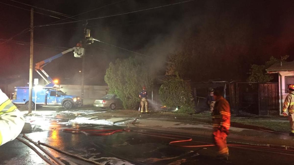 Fresno fire fighters work with Pacific Gas and Electric after a residential fire in central Fresno burns down a power line.