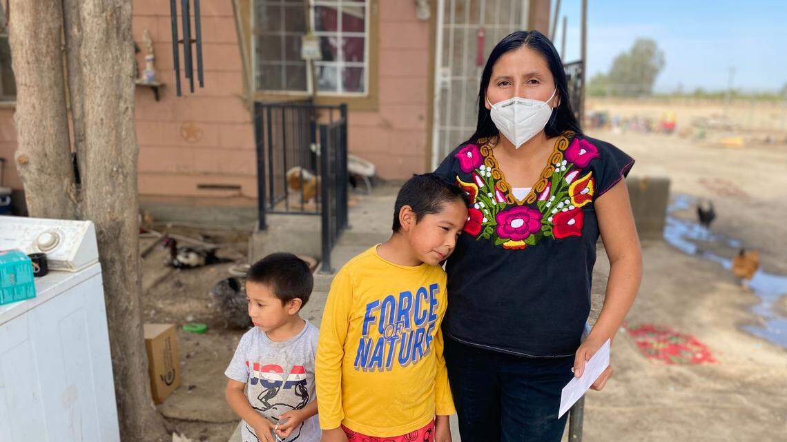 Laura García stands outside her home in Raisin City, a small unincorporated community in Fresno County, with her sons Mateo and Mattias. Her eldest daughter tested positive for COVID-19 in late August.