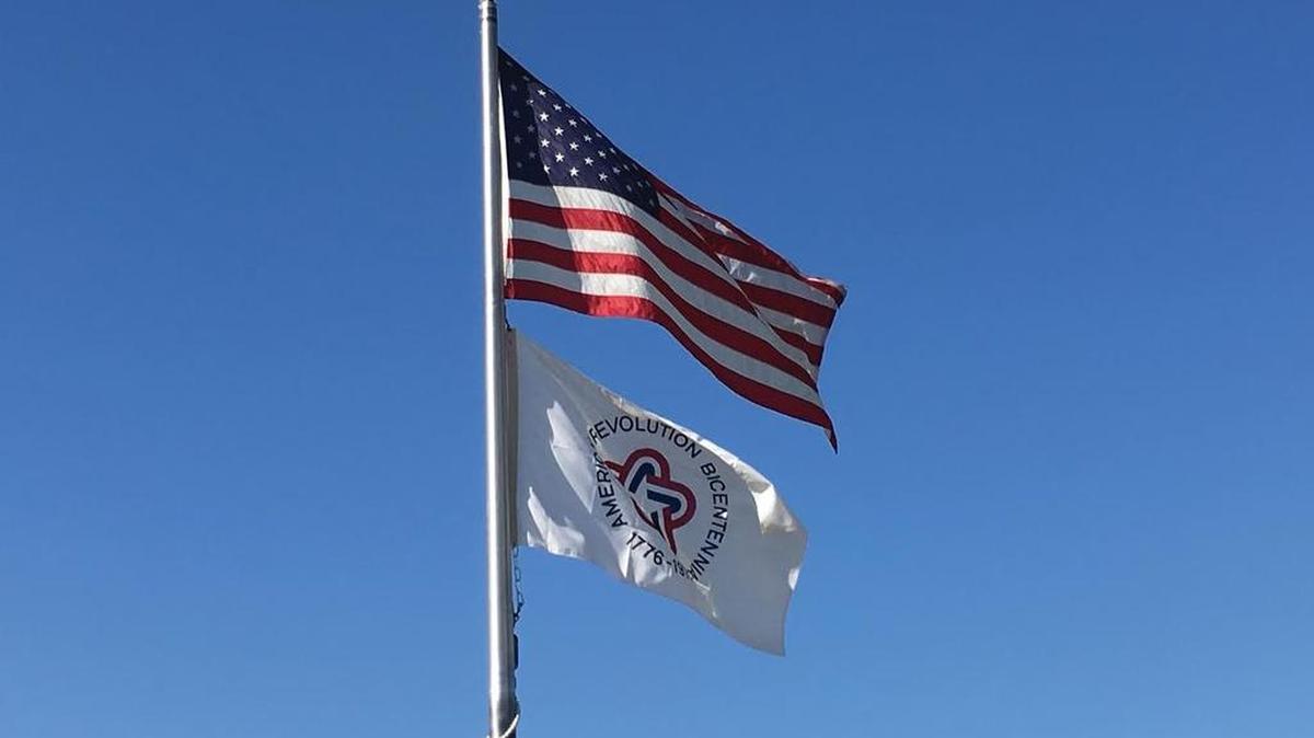 The American Revolution Bicentennial flag flies along with the American Flag at the Save Mart Center at Fresno State in 2016, marking the 40th anniversary of the United States Bicentennial.