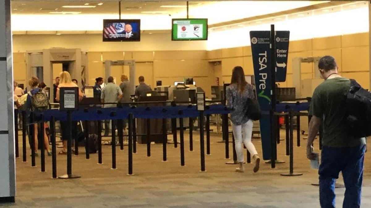 A sign denotes the TSA PreCheck line for streamlined screening as travelers go through Transportation Security Administration lines at Fresno Yosemite International Airport. Passengers with TSA PreCheck approval can keep their shoes, belts and jackets on and leave computers and small bottles of liquid in their carry-on bags during security screening.