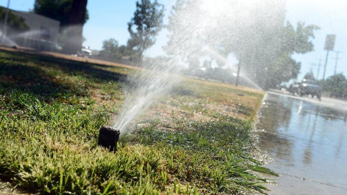 In a July 2014 file photo, sprinklers run on a grassy area in front of Eaton Elementary School in Fresno.