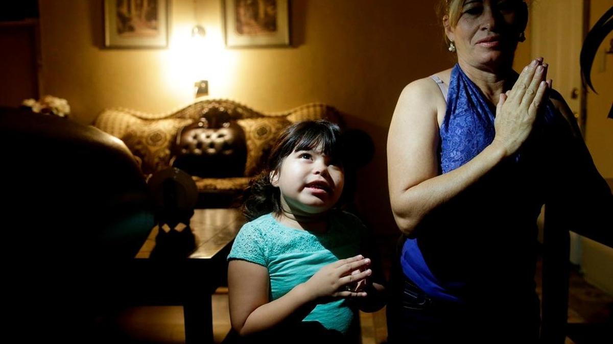 In this July 2, 2015 photo, Yaritza Pizano, 4, left, prays alongside her grandmother, Maria Marquez, in their home in the community of Okieville, on the outskirts of Tulare. As Yaritza’s family began to run out of water in 2014, she began to pray for it during her nightly prayer. “God, give us water so we don’t have to move,” she said in a recent prayer.
