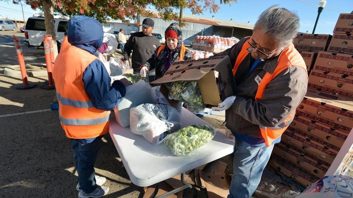 Community Food Bank volunteer Serafin Bedolla, 63, right, of Huron, assembles drought relief packages to be distributed on Nov. 16 in Huron. To get the food packages, workers must either have had their hours reduced or have lost their job because of the drought.