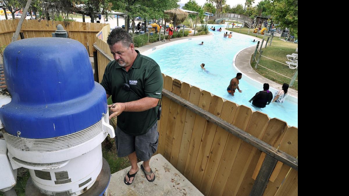 
Robert Rayner, maintenance manager for the Island Waterpark, checks on one of a pair of large circulation pumps which take water from attractions, such as the one at right, to a filtration process for reuse. 
