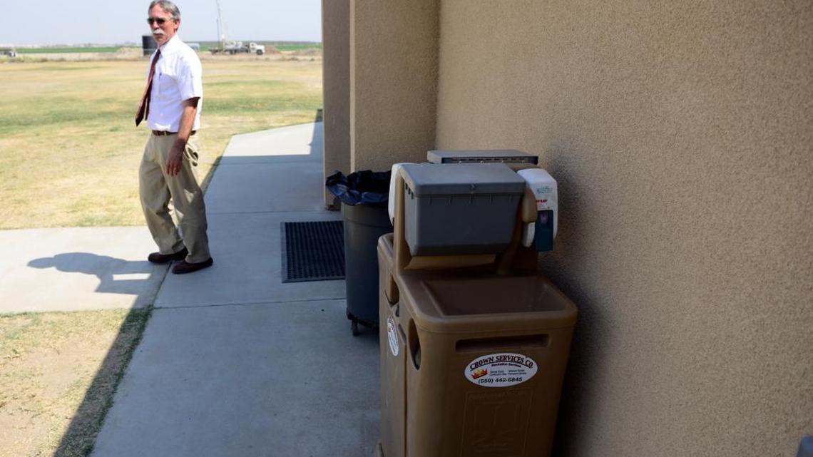 
Loren York, the superintendent of Alview-Dairyland Union School District, walks on Thursday past portable sinks set up for children to use at Alview Elementary School, where the well went dry in late August. A well-drilling truck in the distance was also at work the same day.
