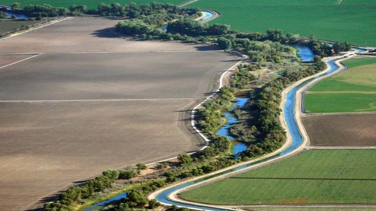 The San Joaquin River, on the left, parallels a canal on the right as it flows past Sack Dam in an aerial photograph taken in 2009 near Firebaugh. The ground may be sinking around Sack Dam due to farm water pumping, according to federal engineers.