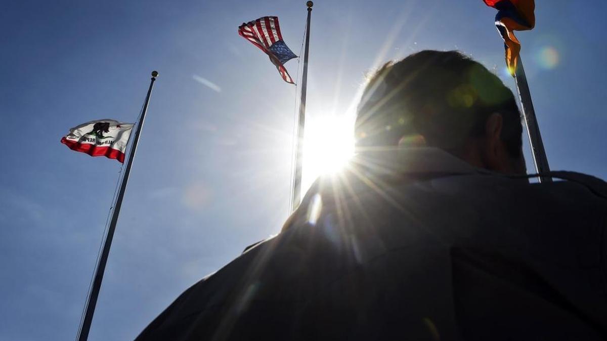 The Armenian flag, right, is flown during a ceremony commemorating the Armenian genocide at Fresno City Hall in 2016.